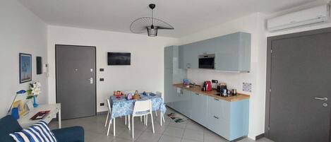 A compact living space with a dining area, kitchenette, and a gray door.