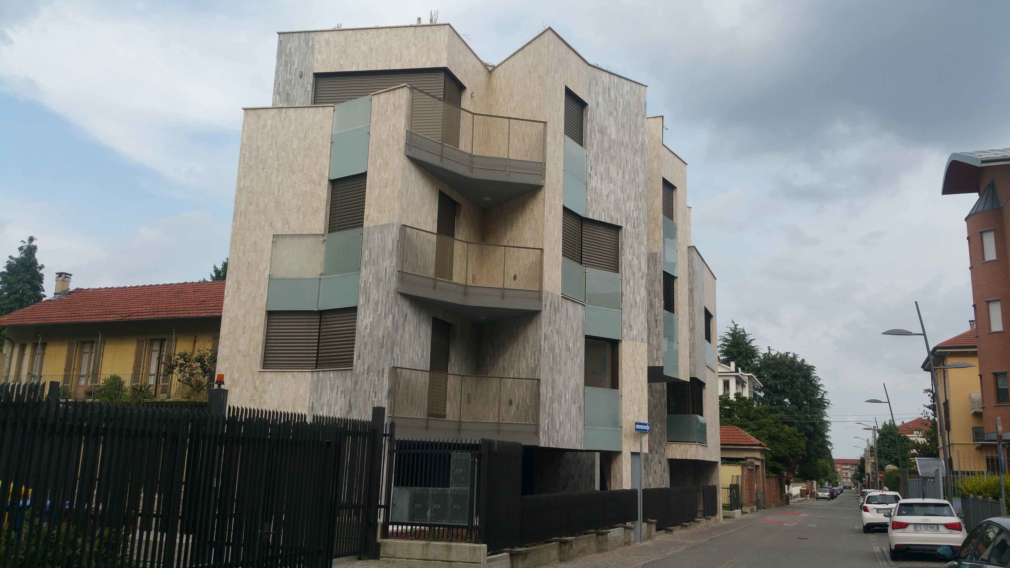 Un edificio moderno a più piani dal design originale, con balconi e ampie finestre.