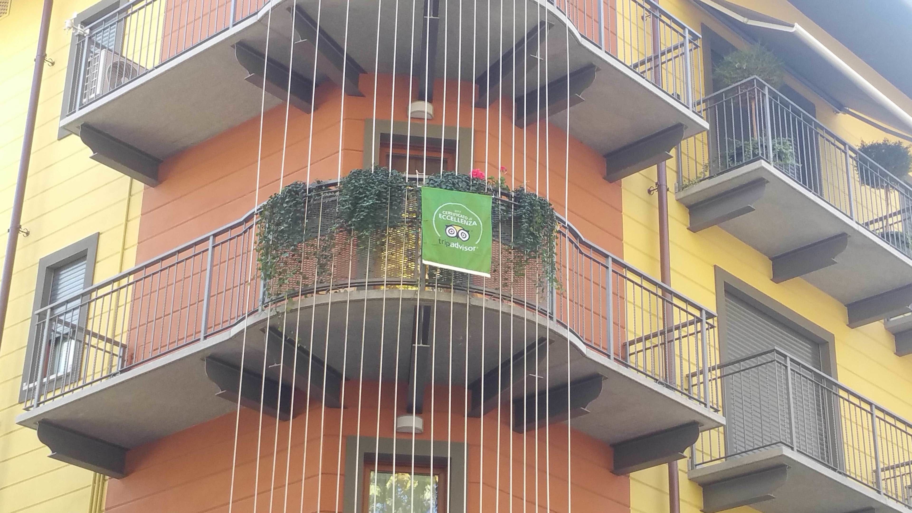 Un edificio de varios pisos con balcones, algunos con plantas.