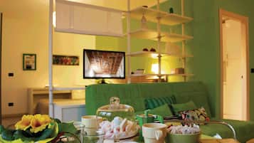 Appartamento Deluxe Verde | Wohnbereich | 45-Zoll-Smart-TV mit Satellitenempfang, Fernseher, Bücher