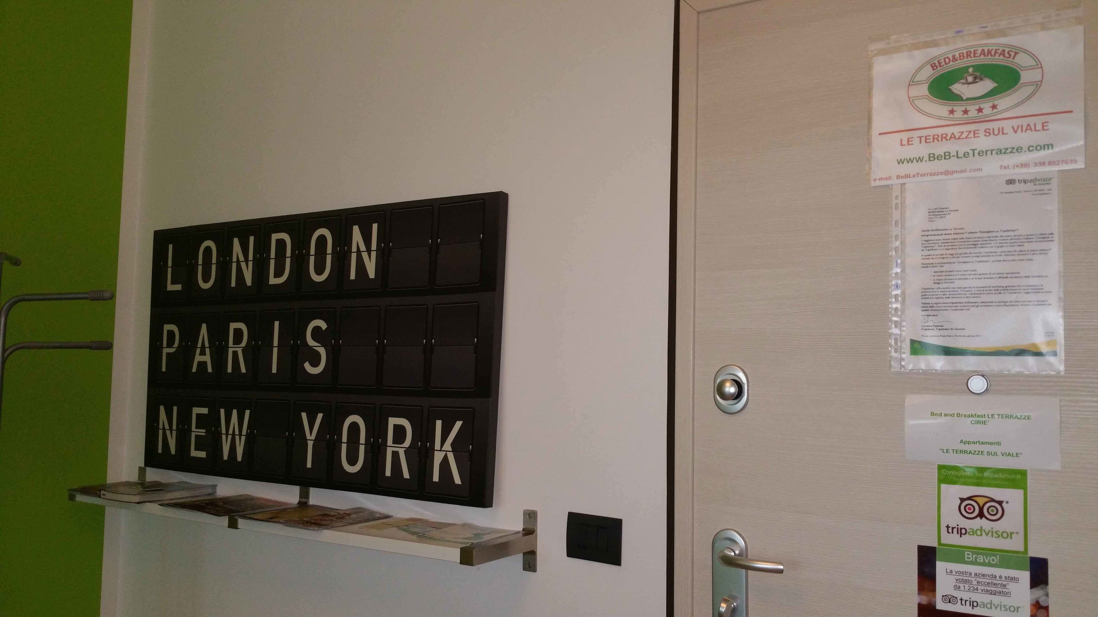Eine Tür mit einem Schild, das 'LONDON PARIS NEW YORK' aufzählt, und einem TripAdvisor-Siegel.