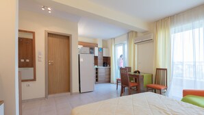 Une chambre d’hôtel comprenant un lit, un bureau, une chaise, un coin cuisine et une salle de bain.