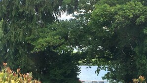 A pathway leading to a body of water, surrounded by greenery and stone structures. - The Old Boathouse (Enniskillen)