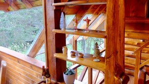 Un intérieur en bois avec une étagère en bois où sont disposés des objets décoratifs et une petite plante en pot.