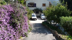 A white building with a small driveway and parked cars. - Exceptional sea view apartment in detached villa Côte d'Azur (Rayol-Canadel-Sur-Mer)