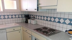 A kitchen with a gas stove, a microwave, a coffee maker, and a toaster. - Exceptional sea view apartment in detached villa Côte d'Azur (Rayol-Canadel-Sur-Mer)