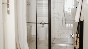 A modern bathroom with a glass shower enclosure, a toilet, and a towel rack. - Cà Bèla - Porta Romana (Milan)