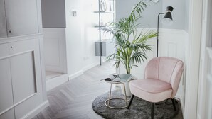 A modern living room with a round rug, a pink chair, a potted plant, and a bookshelf. - Cà Bèla - Porta Romana (Milan)