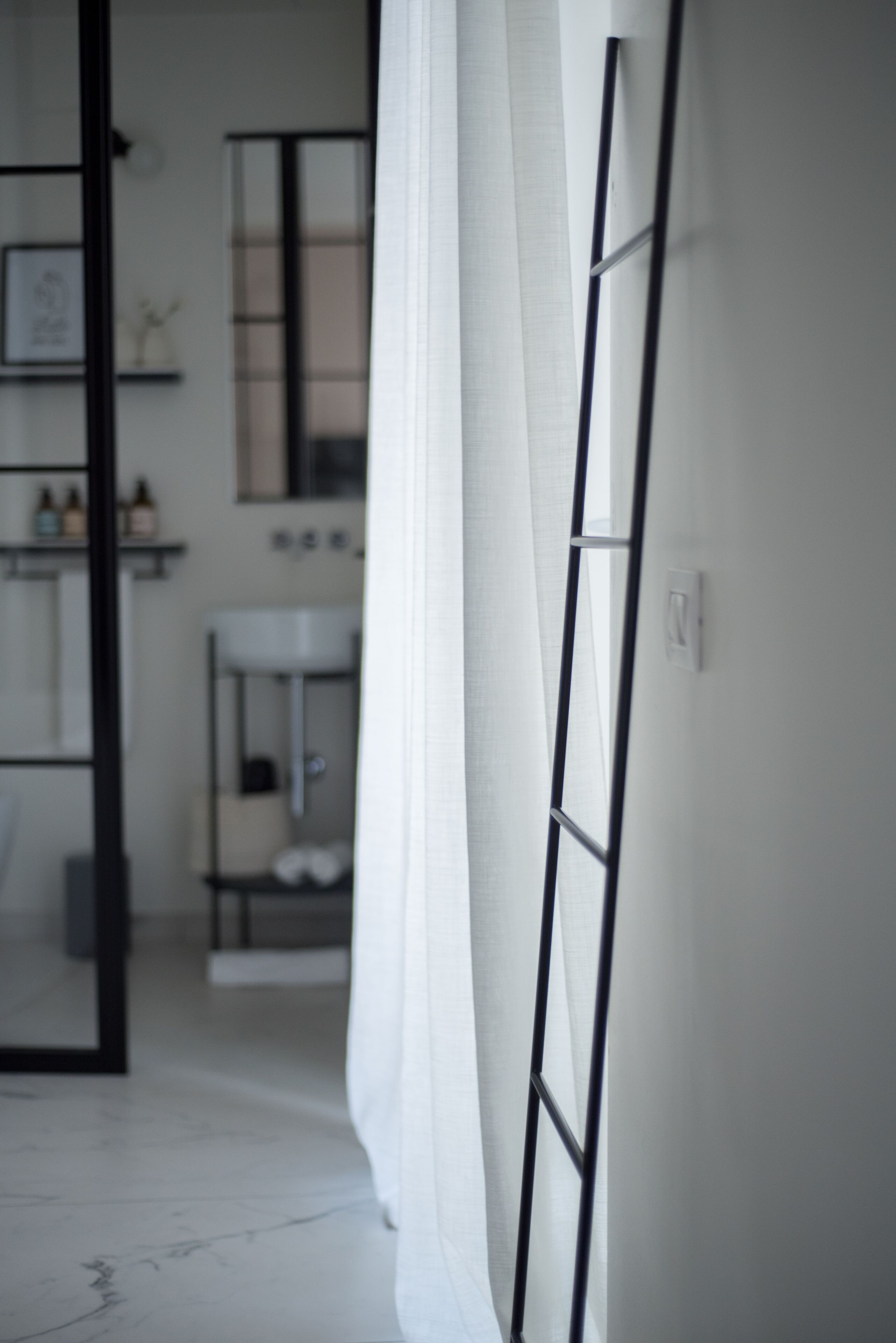 Een badkamer met een spiegel, wastafel en planken met toiletartikelen.