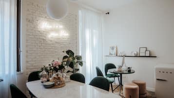 Uma área de refeições moderna com parede de tijolos brancos, um letreiro de neon e decoração minimalista.