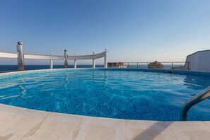 A clear blue pool with a white deck and metal railings, overlooking the sea. - Apartment in Vista Del Mar (Ravda)