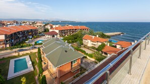 A coastal hotel with multiple buildings, a swimming pool, and a view of the sea. - Apartment in Vista Del Mar (Ravda)