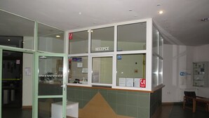 Un espace d’accueil comprenant un comptoir de réception, une porte d’entrée en verre et un panneau indiquant la disponibilité du Wi-Fi.