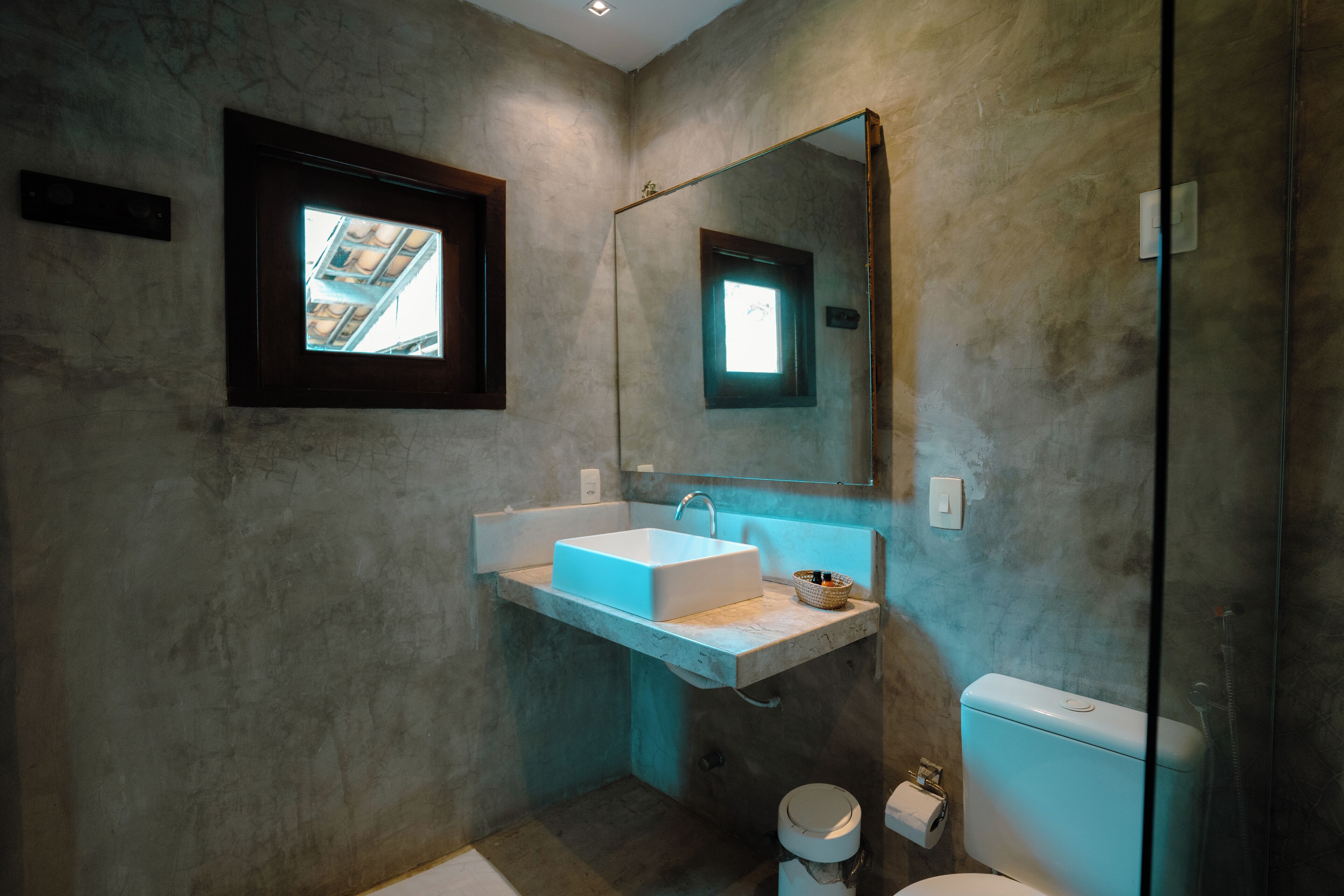 Un baño moderno con lavamanos integrado, un espejo grande y cabina de ducha de vidrio.