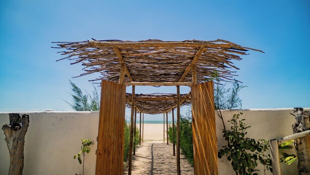 A wooden pergola structure with a clear view of the beach in the background. - Zebra Boutique Hotel (Beberibe)