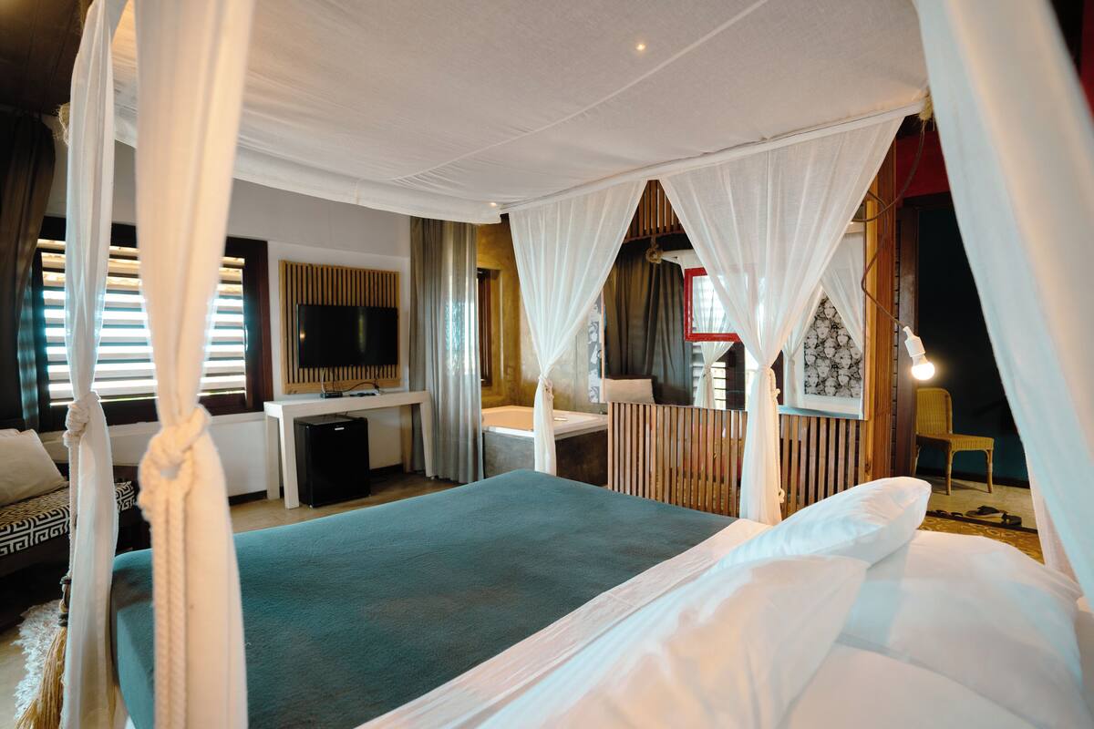 Ein Schlafzimmer mit einem Bett, einem Schreibtisch, einem Fernseher und einem Sessel.
