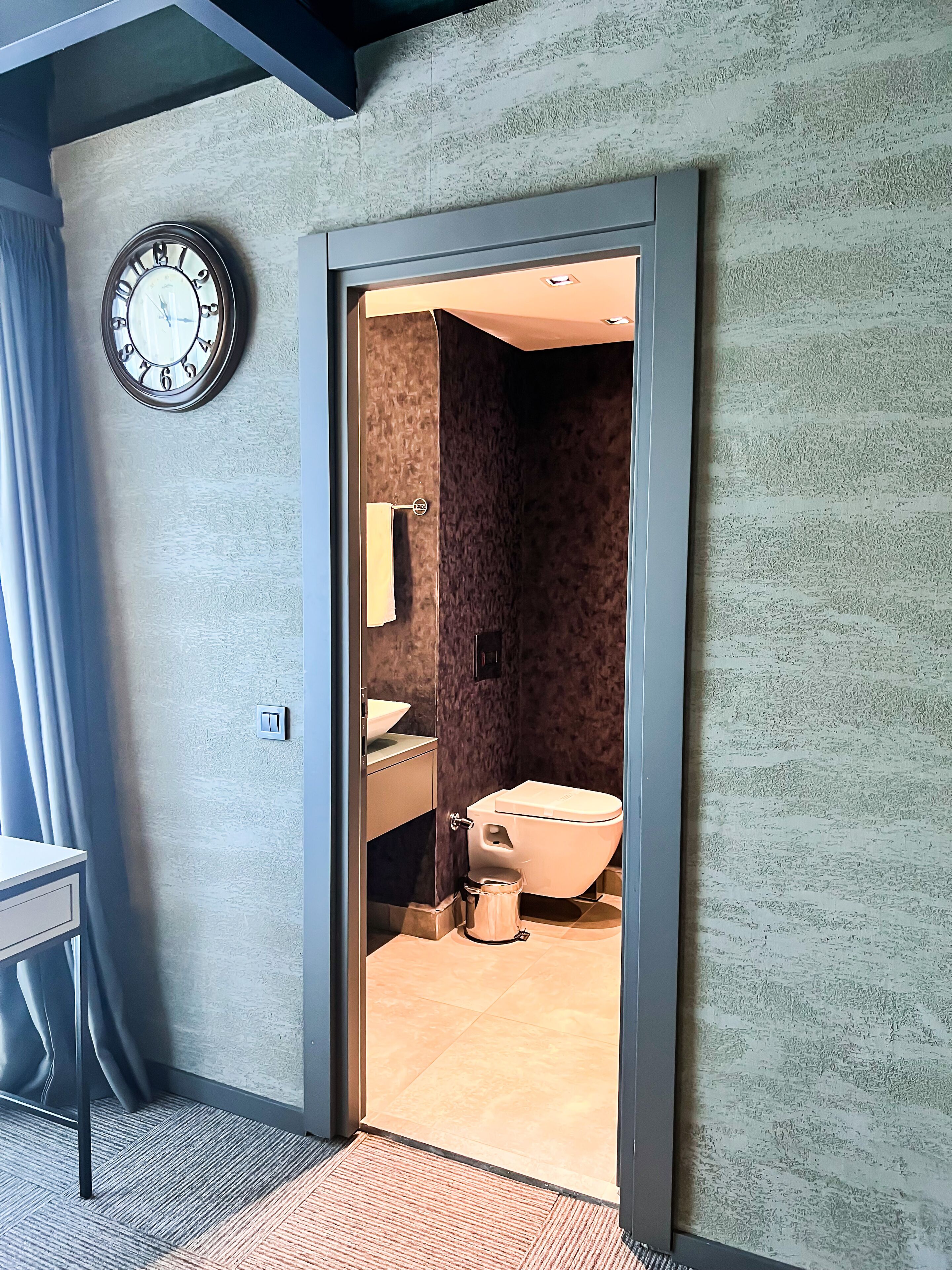 Un baño moderno con inodoro, lavamanos y espejo.
