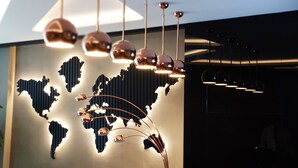 Un intérieur moderne agrémenté d’un mur décoré d’une carte du monde et de luminaires suspendus.
