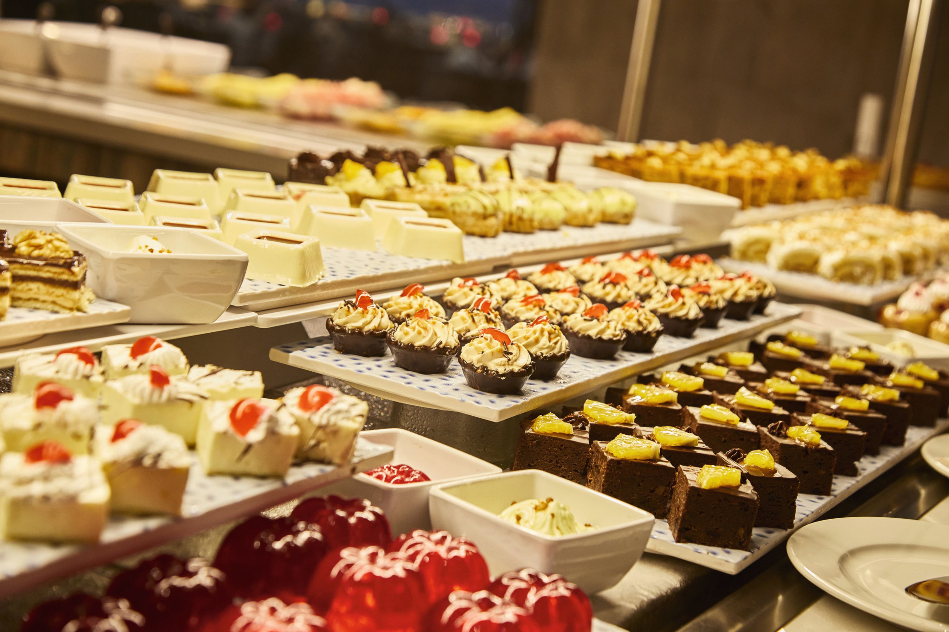 Diverses postres exposades en plats a un bufet.