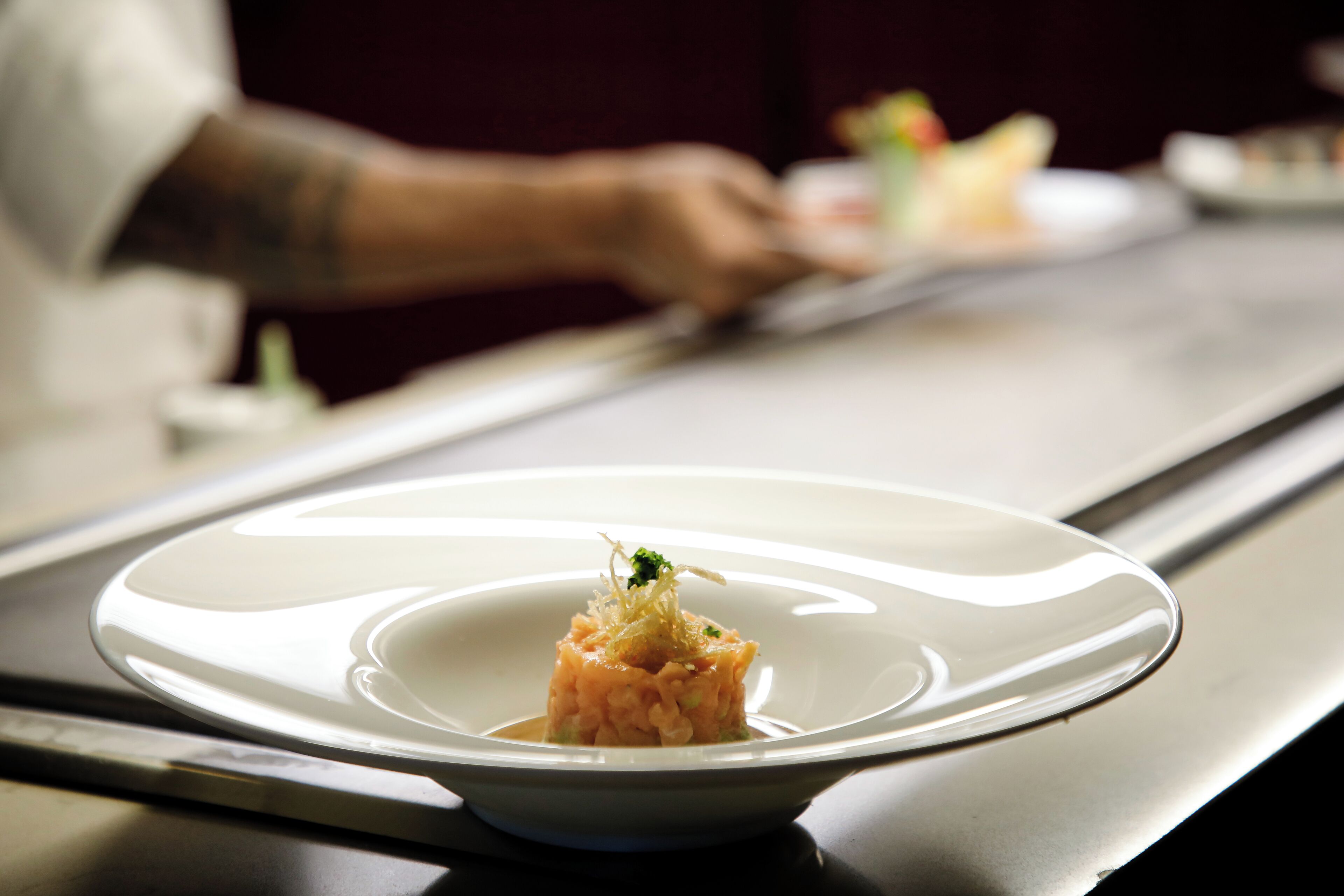 A white plate with a small portion of food on a table.