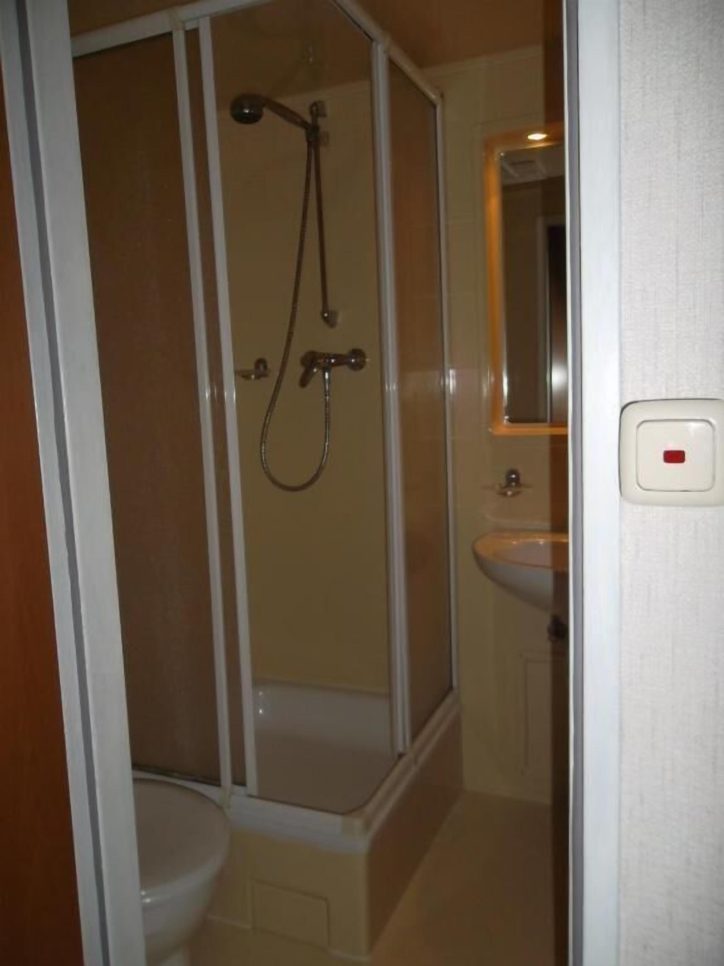 Une salle de bain avec une douche, des toilettes et un lavabo.