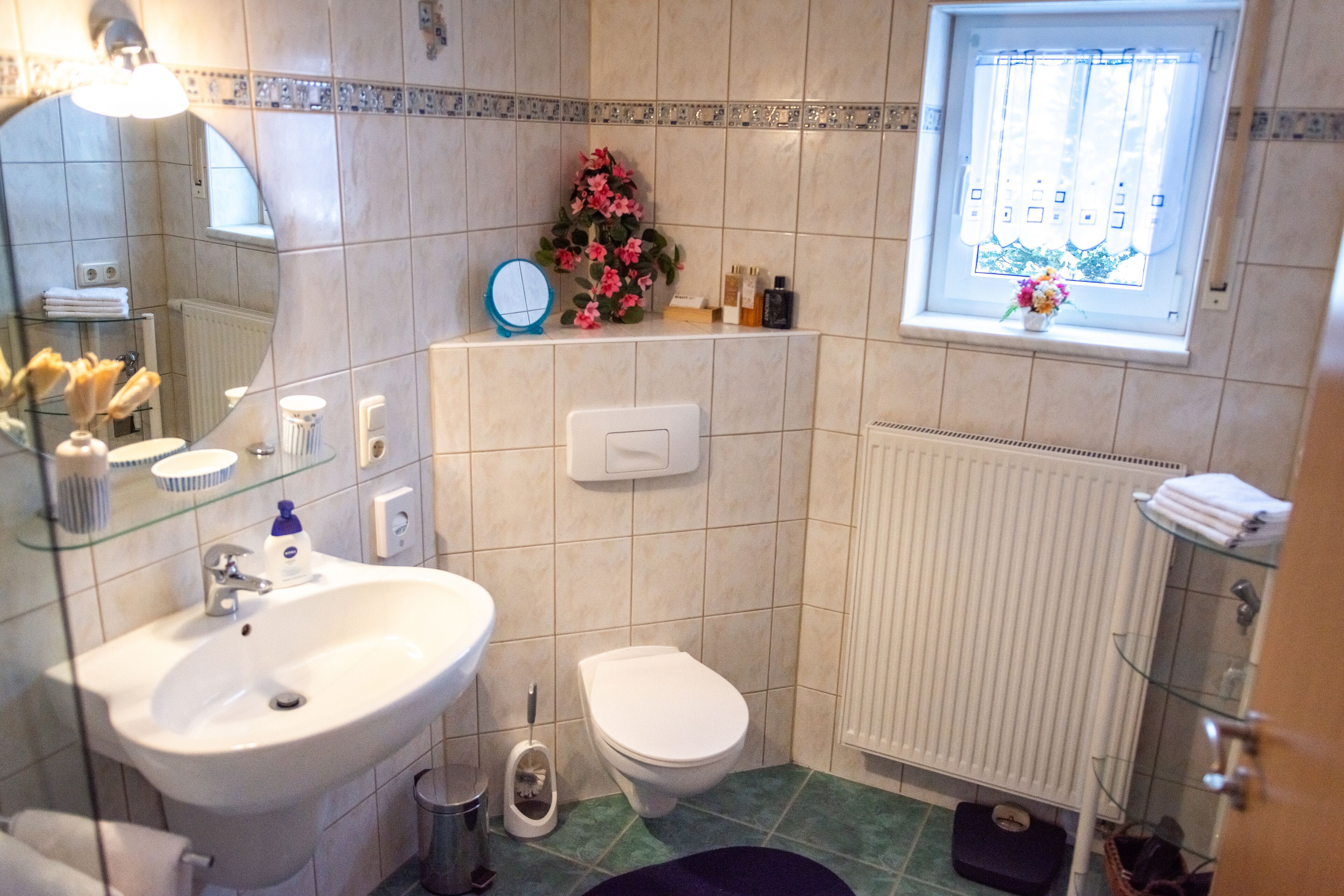 A bathroom with a sink, toilet, and a window with a view.