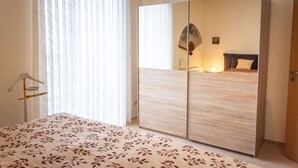 A bedroom with a bed, a wardrobe, and a mirror. - Ferienwohnung Schloss Schönberg (Bad Brambach)