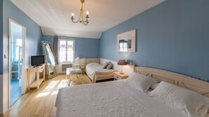 Une chambre à coucher avec un grand lit, une télévision, un bureau et une chaise.