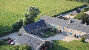 Un bâtiment en pierre doté d’un toit en pente, de nombreuses fenêtres et d’une allée pavée.