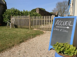 Uma placa com a inscrição 'ACCUEL' e uma seta apontando para a direita, indicando o caminho para a entrada e a área de convívio.