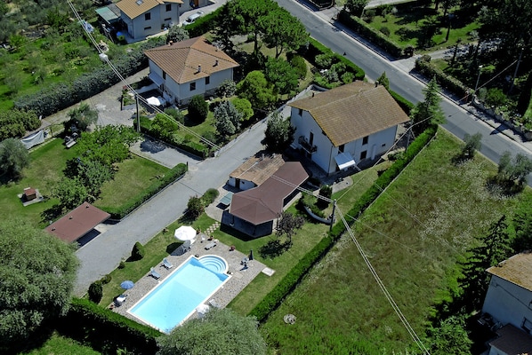 An aerial view of a residential area with houses, a swimming pool, and a well-maintained lawn. - Big house (Castiglione del Lago)