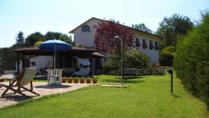 A house with a patio area, a lawn, and a small garden.