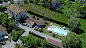 An aerial view of a residential area with a swimming pool, houses, and a well-maintained lawn.
