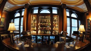 Eine Bar mit einer großen Auswahl an Spirituosen, zwei Lampen und einer gebogenen Bar.