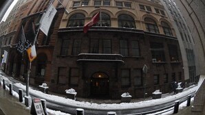 Ein historisches Gebäude mit einer klassischen Fassade, großen Fenstern und einem markanten Eingang.