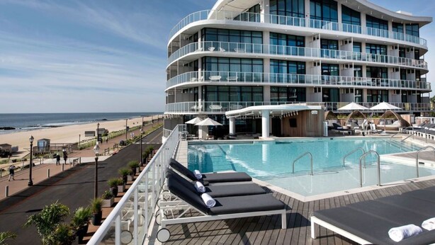 A modern hotel with a pool area, multiple balconies, and a view of the beach. - Wave Resort (Long Branch)