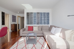 Relax in this stylish living room with a city view, featuring a comfortable sofa, a coffee table, and a cozy chair.