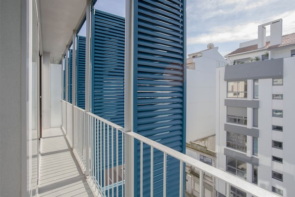 Overlooking the city, this residence features a balcony with shutters and railings.
