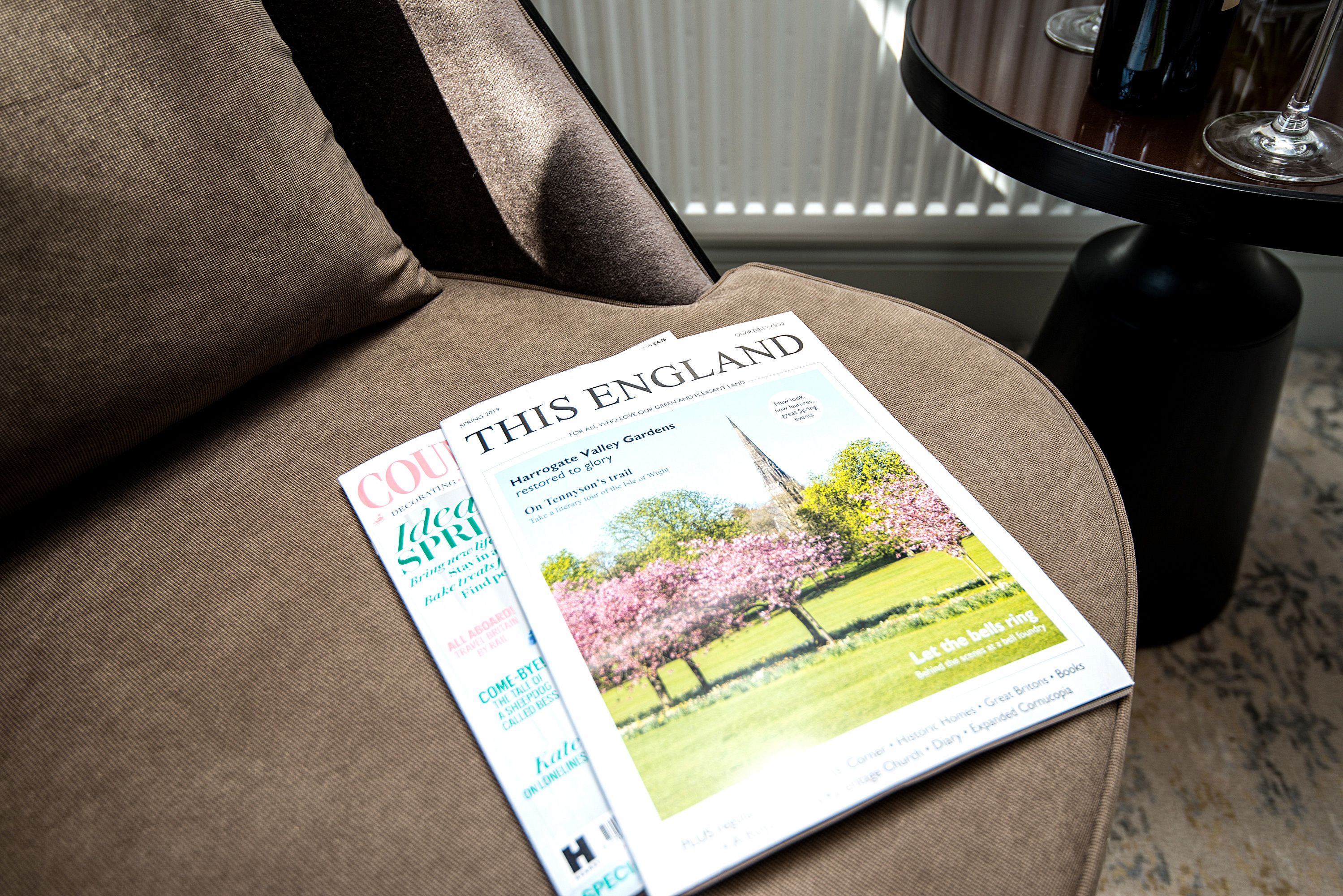 A magazine on a brown upholstered chair.