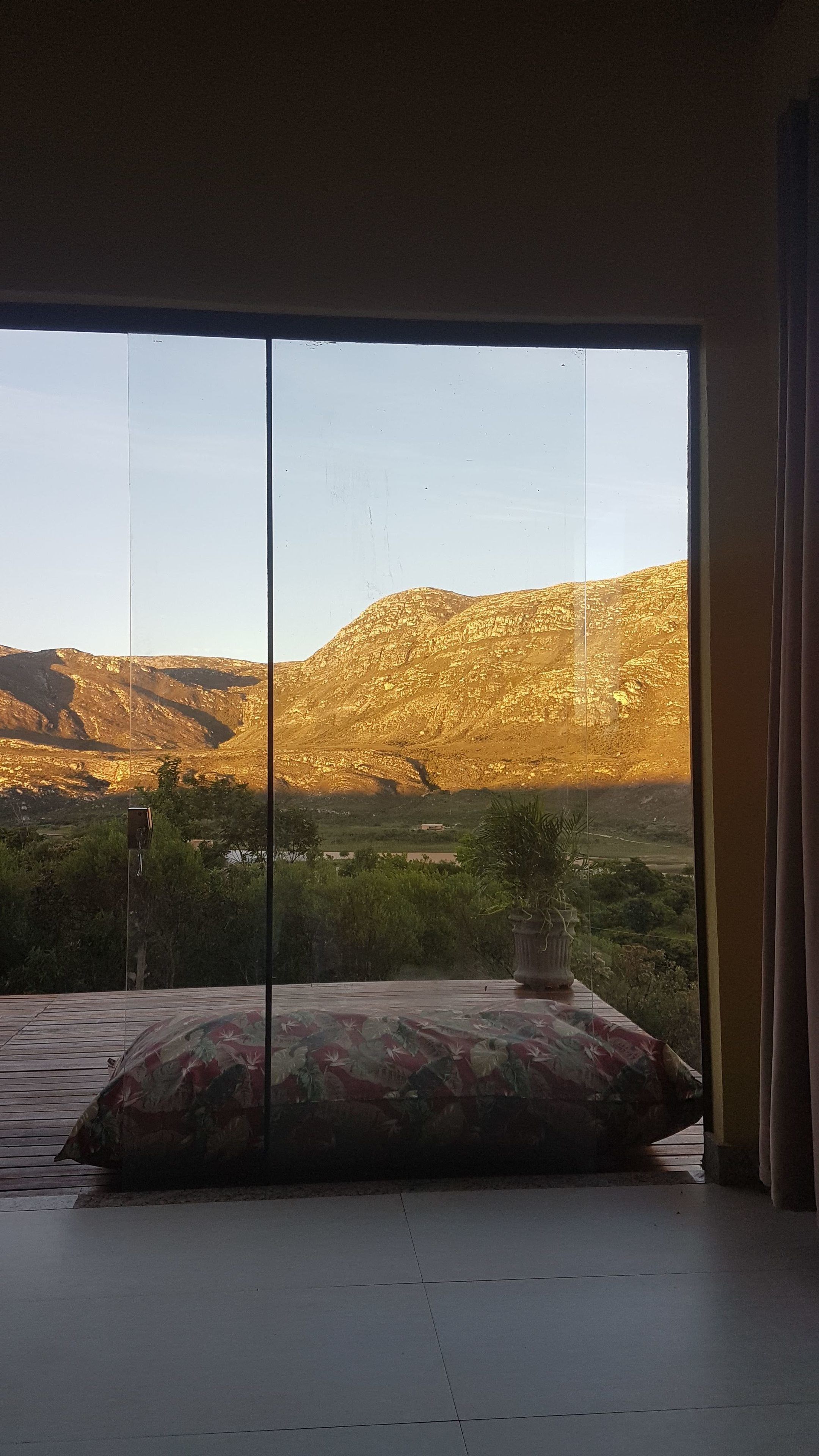 A room with a large sliding glass door leading to a mountainous landscape.