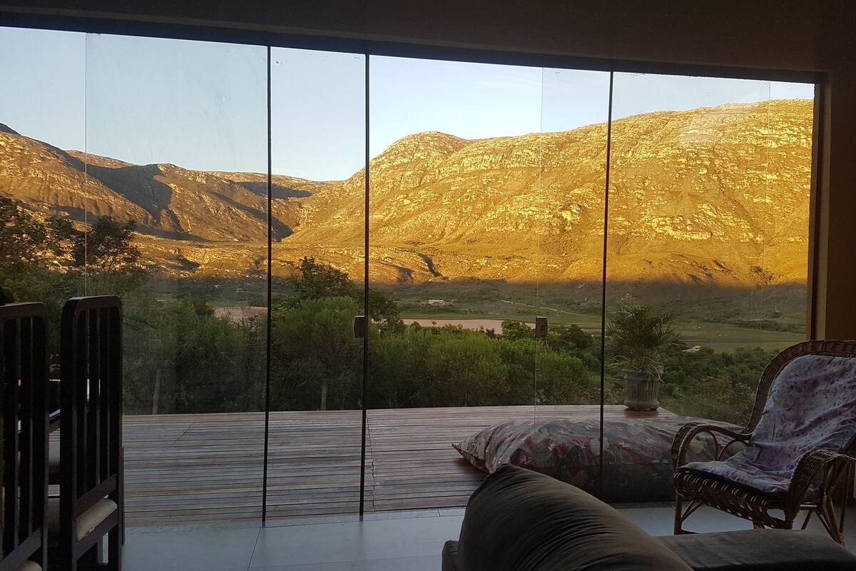 A room with a large glass door leading to a balcony with a mountain view.