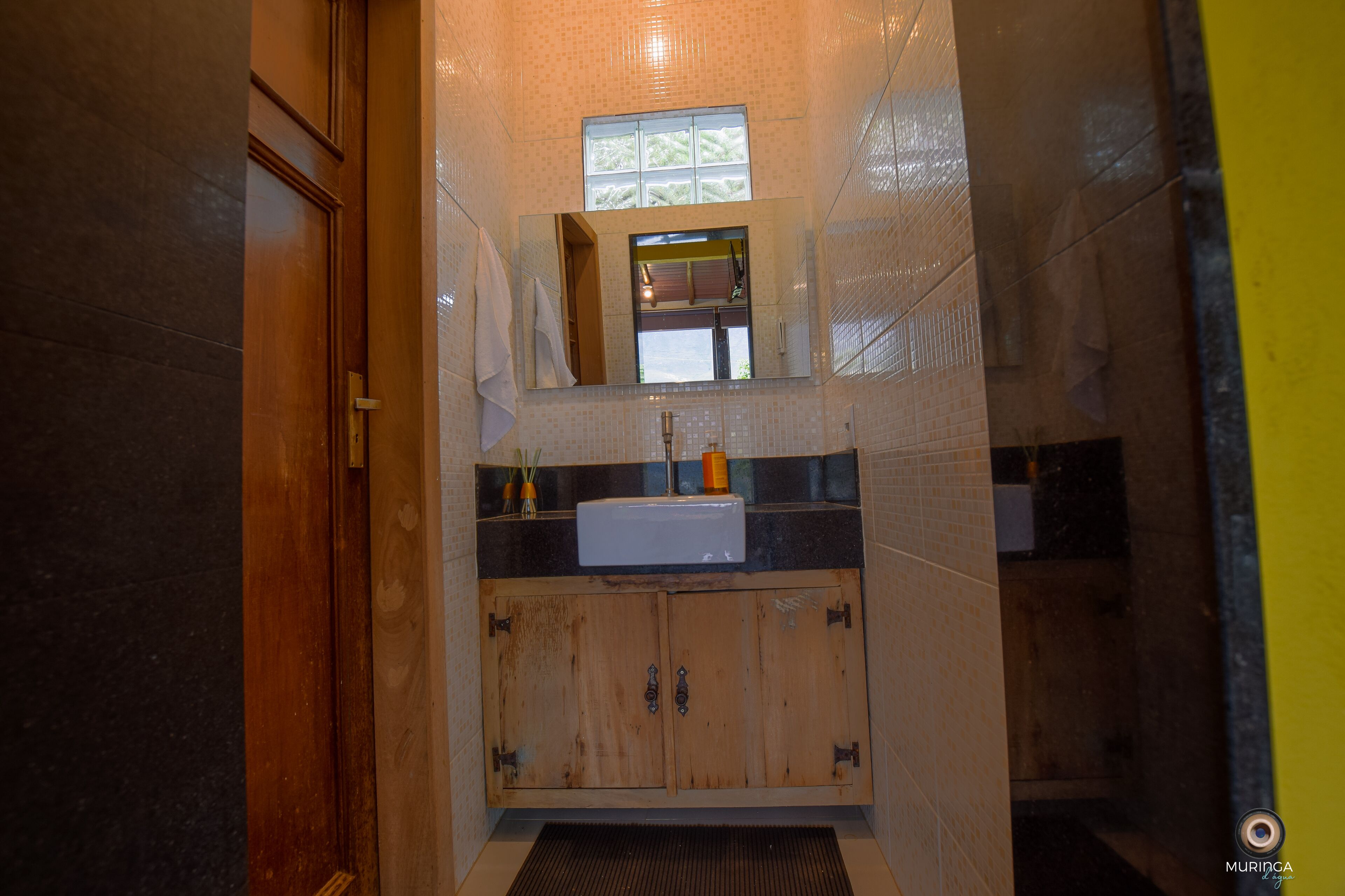 A bathroom with a wooden vanity, a sink, and a mirror.
