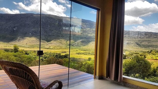 Una habitación con un gran ventanal que da a una vista panorámica de un paisaje montañoso.