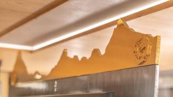 Un interior moderno con un muro decorativo que presenta un diseño con forma de montaña.