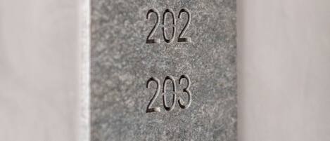 A sign with the word "ROOMS" and numbers 201 to 204, indicating room numbers.