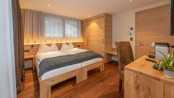 Un dormitorio moderno con una cama de madera, mesitas de noche, un escritorio y una planta en maceta.
