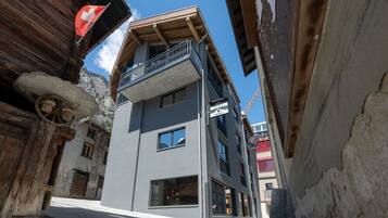 Une rue étroite bordée d’un immeuble moderne doté de balcons et de grandes fenêtres.