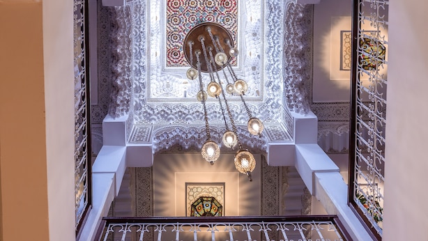 A grand staircase with ornate railings and a decorative ceiling featuring intricate patterns and a central chandelier. - Riad Kech Soul Boutique & SPA (Marrakech)