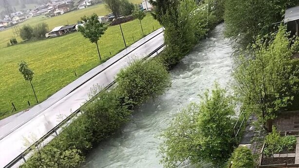 A river flowing alongside a paved path with greenery on one side and a residential area on the other. - Appartementhaus Holiday & Villa Theresa (Kaprun)