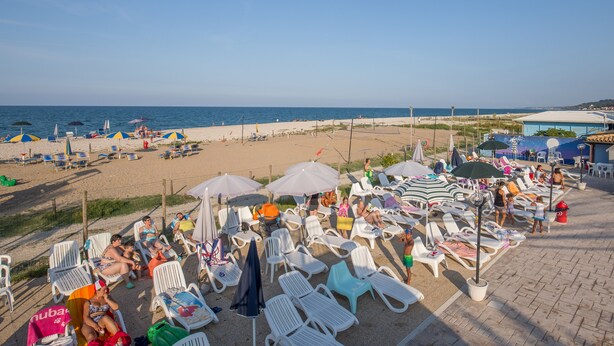 A beach with sun loungers and umbrellas, a clear sky, and the sea in the background. - Camping Sun Beach (Torino di Sangro)
